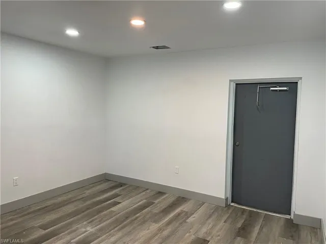Empty room featuring recessed lighting and dark wood-style floors