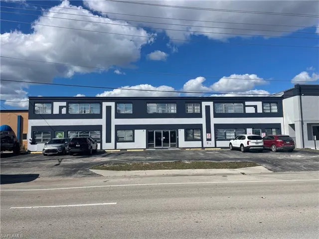 View of commercial property with uncovered parking