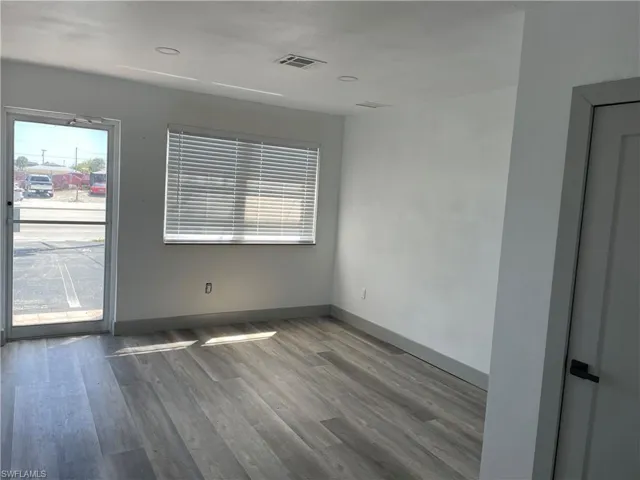Empty room featuring dark wood-type flooring and baseboards