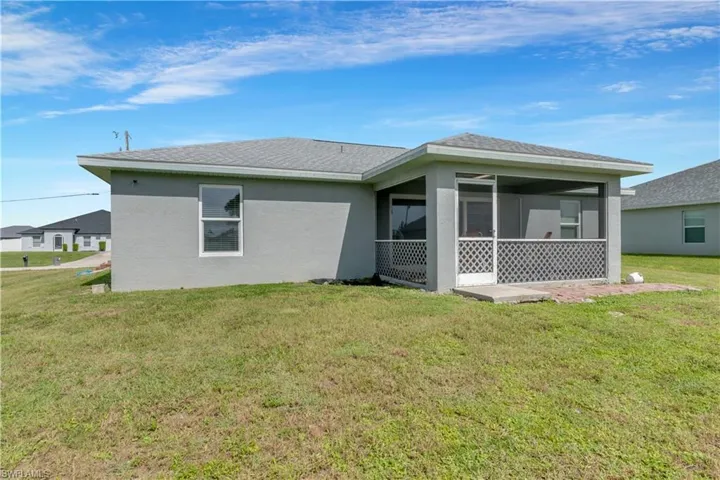 Back of house featuring a sunroom and a lawn