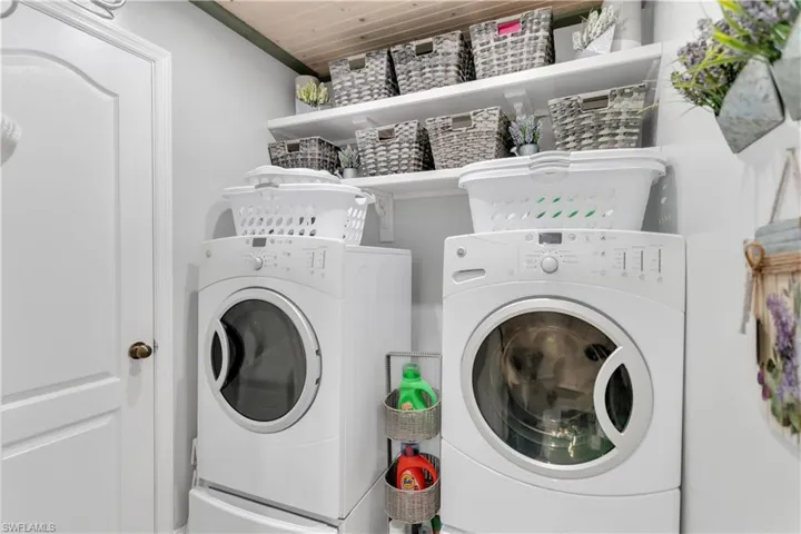 Laundry area with separate washer and dryer and wood ceiling