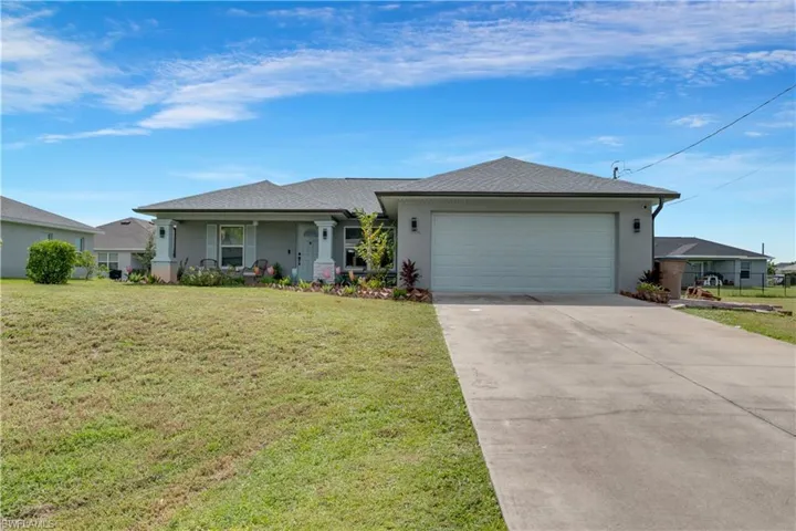 Ranch-style home featuring a garage and a front lawn