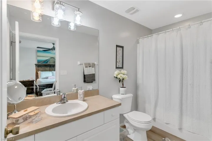 Full Master bathroom with ceiling fan, toilet, shower / bath combo with shower curtain, and vanity