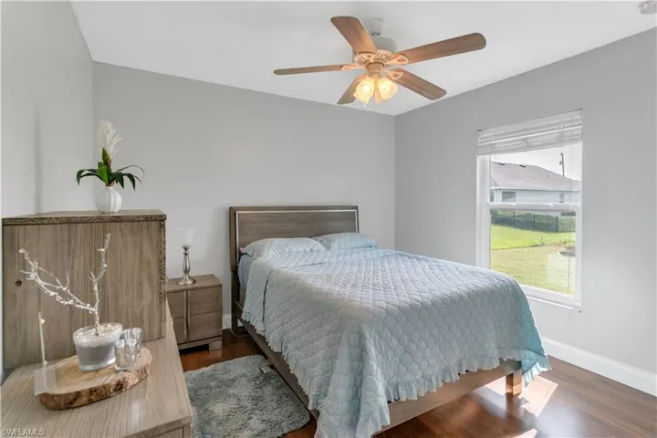 Bedroom featuring ceiling fan and dark wood-type flooring