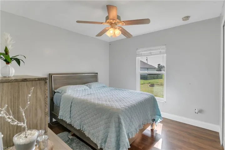 Bedroom with ceiling fan and dark hardwood / wood-style floors