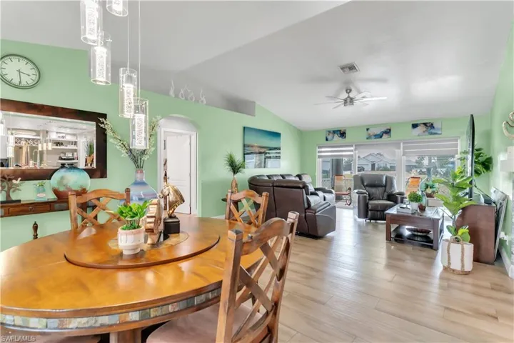 Dining space featuring ceiling fan, vaulted ceiling, and light wood-type flooring
