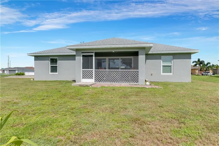 Rear view of house featuring a lawn and a sunroom