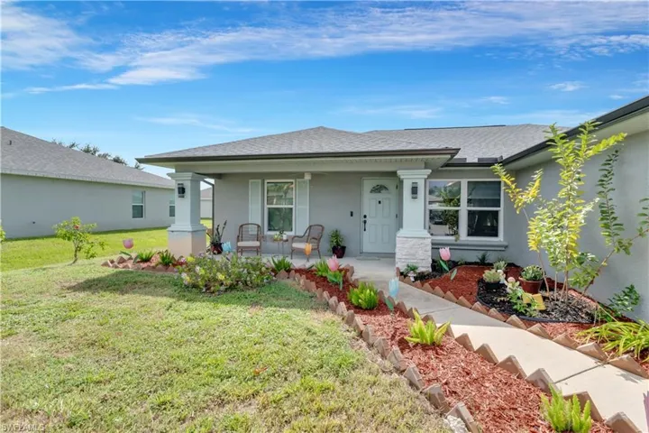 Ranch-style house featuring a porch and a front yard