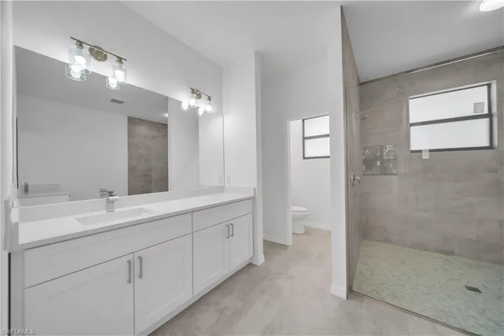 Bathroom featuring vanity, walk in shower, and light tile patterned floors