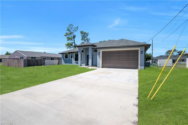 Prairie-style house with concrete driveway, stucco siding, a shingled roof, and a garage