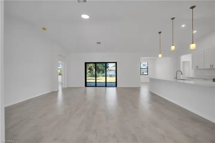 Unfurnished living room with recessed lighting and high vaulted ceiling
