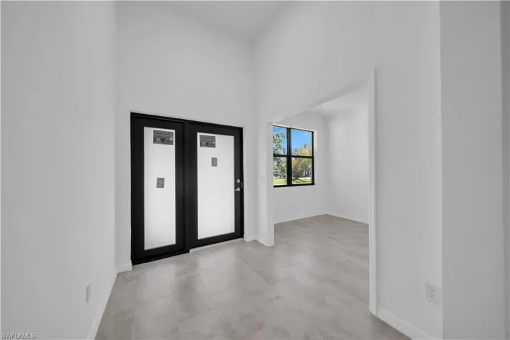 Foyer with baseboards and light tile patterned floors