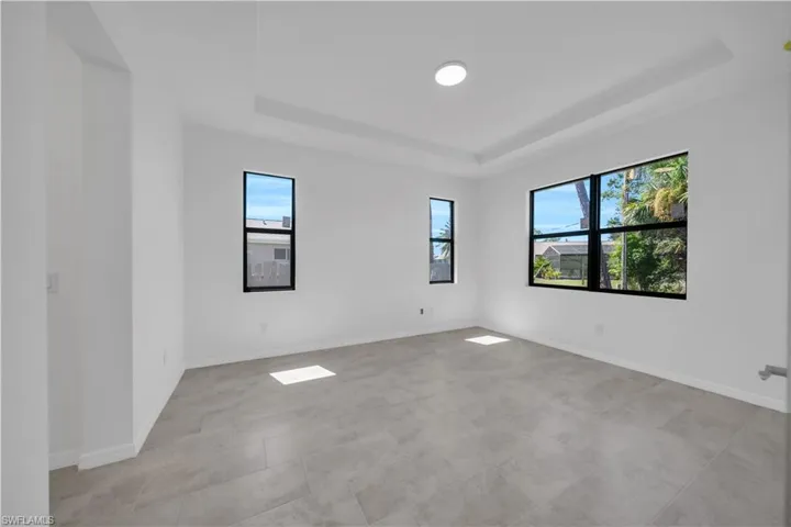 Empty room featuring a raised ceiling and light tile patterned floors