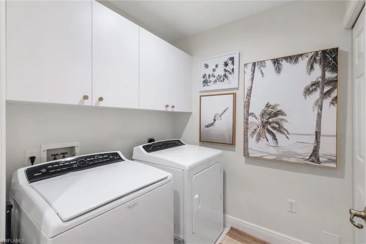 Washroom featuring cabinet space and washer and clothes dryer