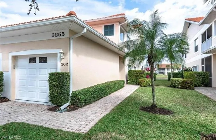 View of home's exterior with stucco siding, a lawn, and an attached garage
