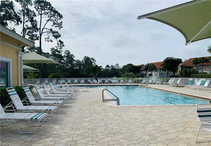 Community pool featuring a patio and fence