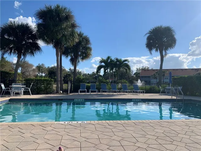 Community pool featuring fence and a patio area