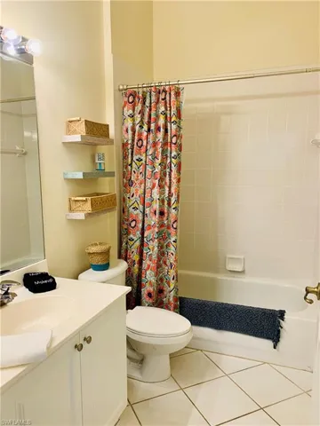 Full bath featuring toilet, shower / bath combo, tile patterned flooring, and vanity