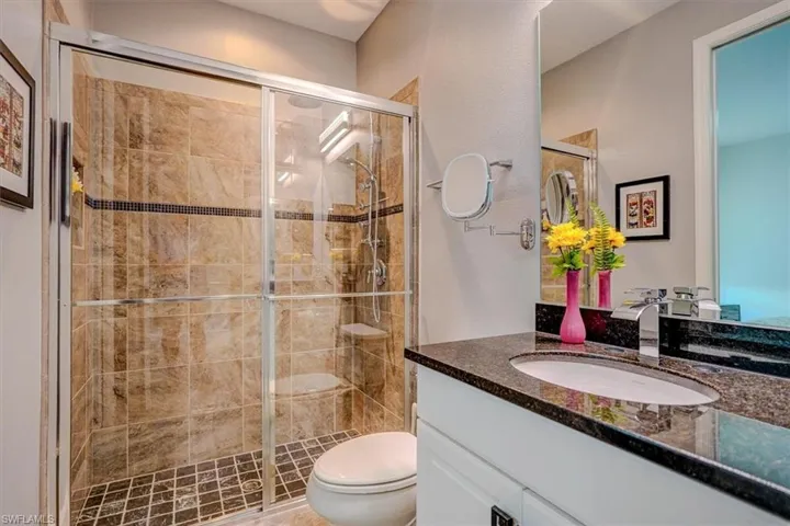 Guest Bathroom featuring vanity, toilet, and walk in shower