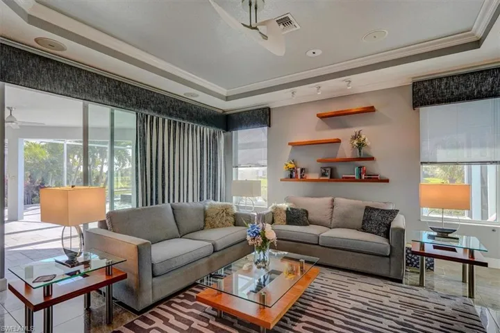 Family room with ceiling fan, ornamental molding, and a tray ceiling