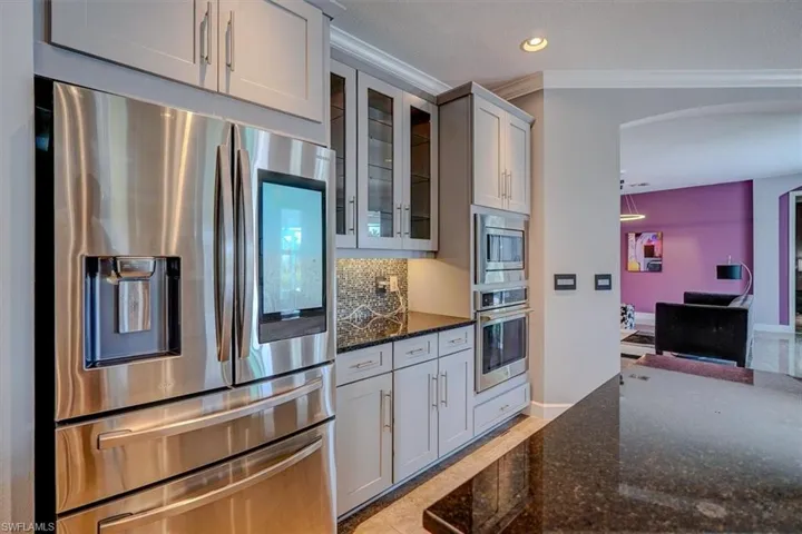 Kitchen with wet bar, tasteful backsplash, ornamental molding, and appliances with Internet and storage capabilities.