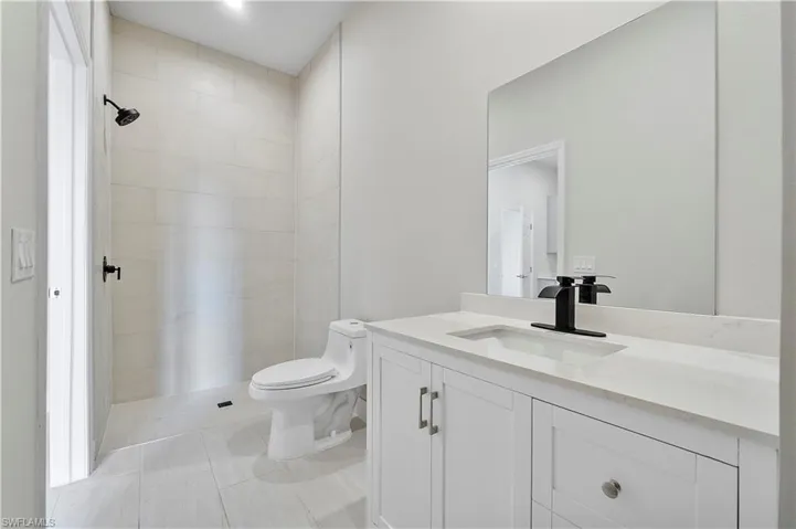 Full bathroom featuring toilet, tile patterned flooring, and vanity