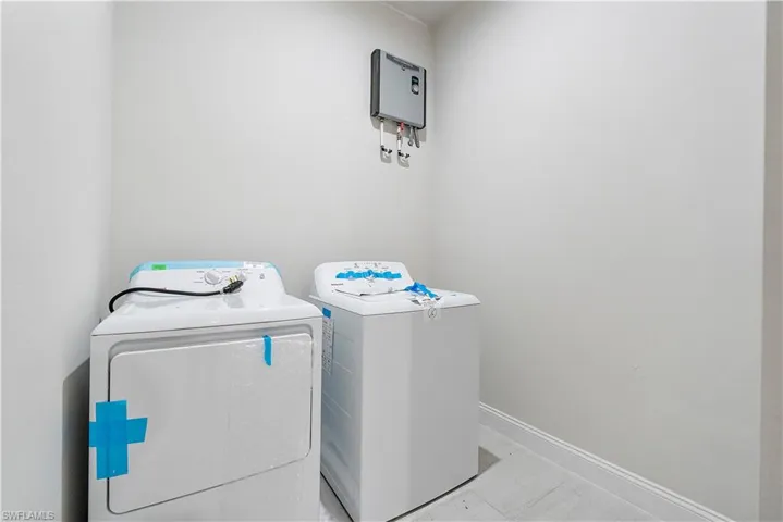 Washroom featuring laundry area, baseboards, and separate washer and dryer