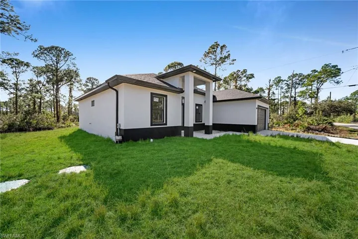 View of front facade featuring a front yard and a garage