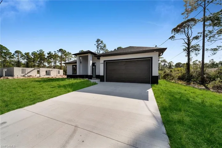 View of front facade with a garage and a front lawn
