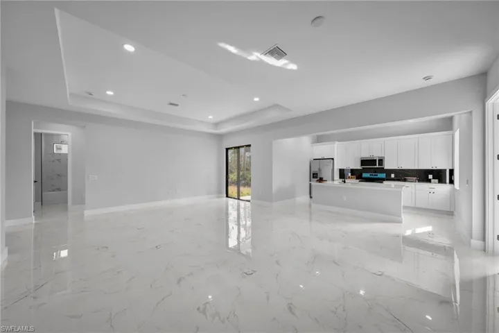 Unfurnished living room with a raised ceiling