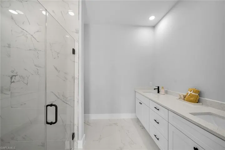 Bathroom featuring vanity and a shower with door