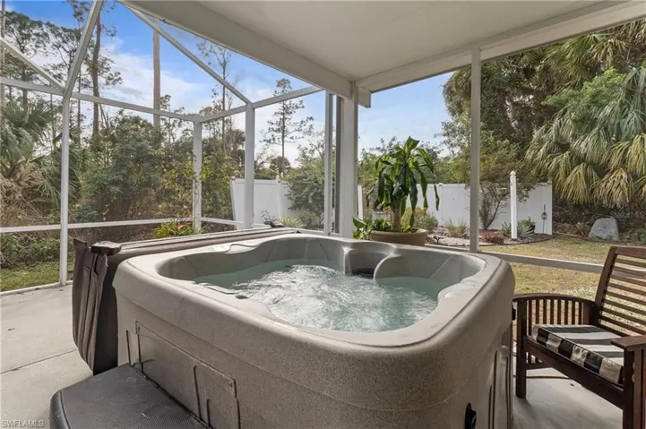 Sunroom / solarium with a hot tub and a patio area