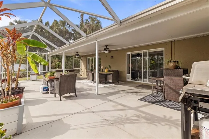 View of patio / terrace with outdoor dining area, a sunroom, ceiling fan, a lanai, and area for grilling