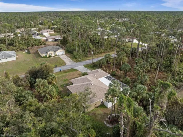 Aerial view of residential area featuring a heavily wooded area
