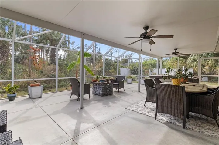 Sunroom featuring outdoor dining space, a patio, and a ceiling fan