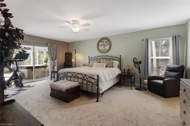 Bedroom with access to exterior, light colored carpet, and a ceiling fan