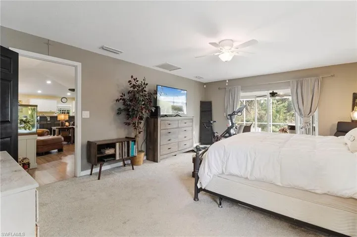 Bedroom with light carpet, access to exterior, and a ceiling fan