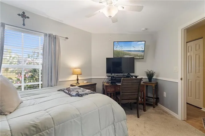 Bedroom with light colored carpet and ceiling fan