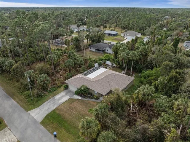 Aerial perspective of suburban area featuring a heavily wooded area