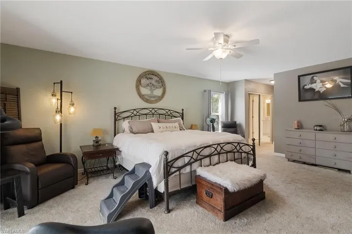 Bedroom featuring carpet, ceiling fan, and ensuite bathroom