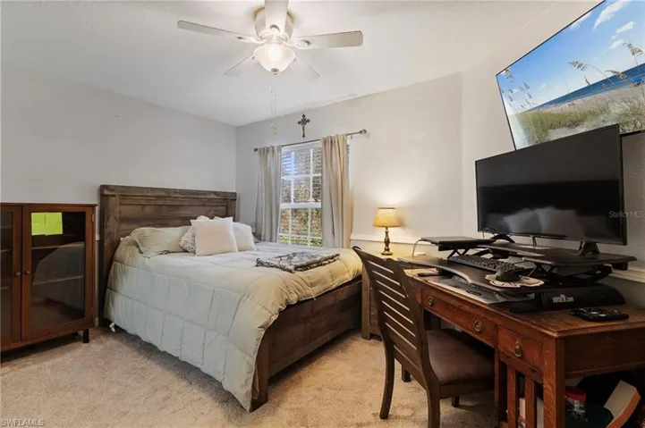 Carpeted bedroom featuring a ceiling fan