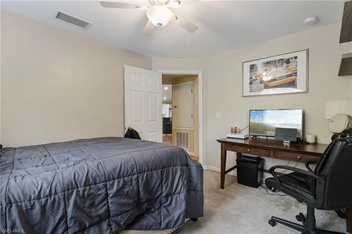 Bedroom featuring an office area, carpet, and ceiling fan