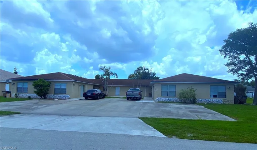 Single story home with stone siding, driveway, a front yard, and stucco siding