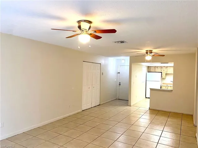 Spare room featuring a ceiling fan and light tile patterned flooring