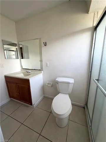 Bathroom with light tile patterned flooring, vanity, and a stall shower