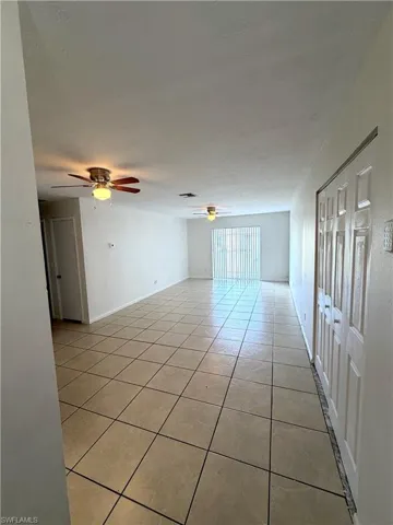 Unfurnished room with light tile patterned flooring, a ceiling fan, and a textured ceiling