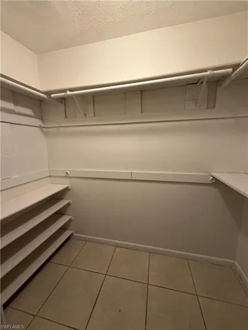 Walk in closet with light tile patterned floors