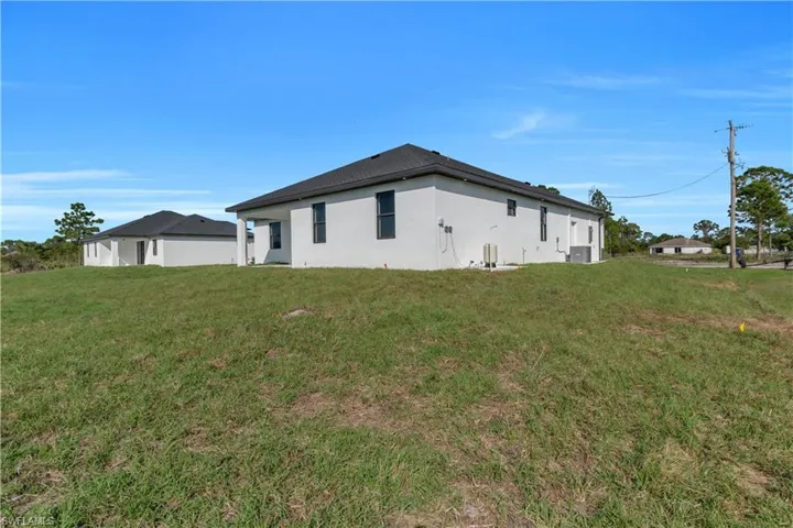 View of side of property with stucco siding and a lawn