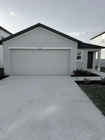 Ranch-style home featuring concrete driveway, stucco siding, and an attached garage