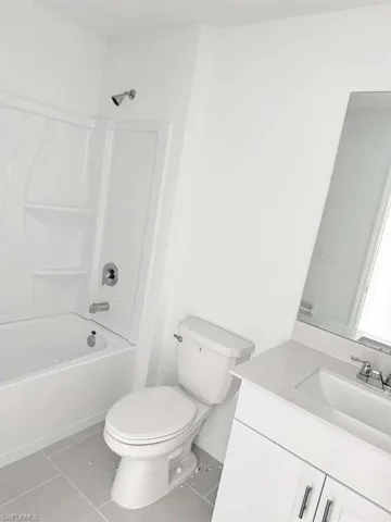 Bathroom with light tile patterned flooring, vanity, and bathing tub / shower combination